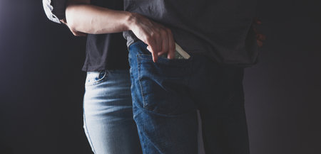 girl takes money from man's pocketの写真素材