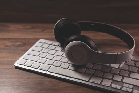headphones with keyboard on wooden table