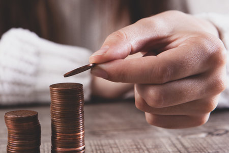 woman hand holding coins on wood table with money and coins, business concept