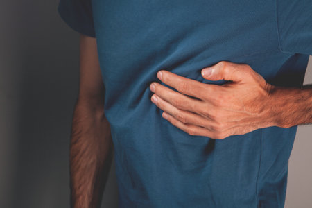 man in blue t-shirt with his hand on his stomach