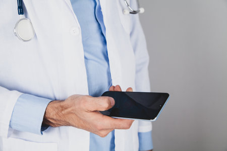 close up of doctor hand holding smart phone with blank screen
