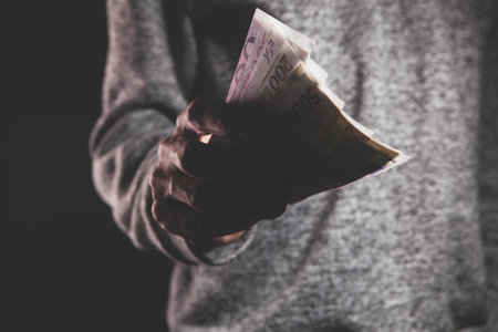 man holding money on black backgroundの写真素材