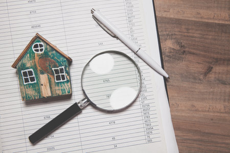 magnifying glass, pen, calculator on table with documents, top view. real house conceptの写真素材