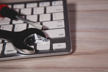 laptop computer with wrench and tools on the table.の写真素材