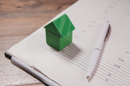 paper house with a pen and paper on a tableの写真素材