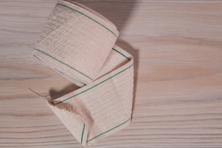 a pile of white and green cotton bags on a wooden background.の写真素材