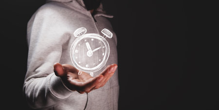 businessman hand holding clock icon in time