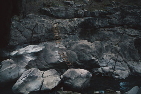 a vertical shot of a beautiful waterfall on a rocky mountainの写真素材