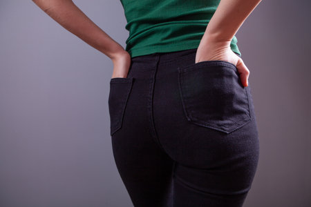 woman in black trousers and t - shirt on a dark backgroundの写真素材