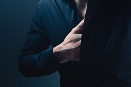 Man in a black shirt on a dark background. Close-up.の写真素材