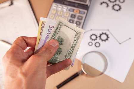 Businessman counting money and using a magnifying glass. Business conceptの写真素材