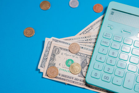 Calculator and money on a blue background. Financial concept.