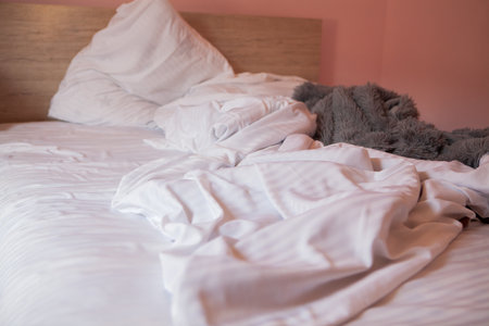 white bed in pink bedroom with pillows, bed and pillowsの写真素材