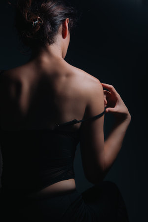 Portrait of a young woman in black lingerie on a dark background