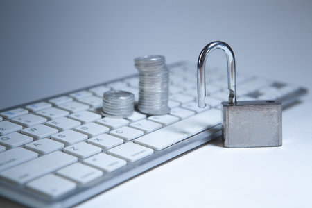 Locked computer keyboard with coins and padlock on white background.