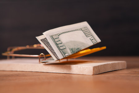 Dollars in a mousetrap on a wooden backgroundの写真素材