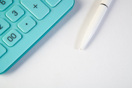 Calculator and pen on a white background with copy space.の写真素材