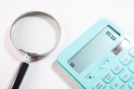 calculator and magnifying glass on white background, business conceptの写真素材