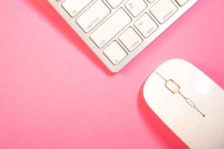 Computer keyboard and mouse on pink background. Top view with copy spaceの写真素材