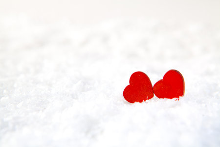 Two red hearts on white snow. Valentines day background. Copy space.の写真素材