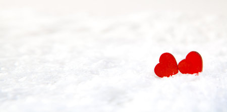 Two red hearts on white snow background. Valentines day concept.の写真素材