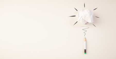 Crumpled paper ball and pencil on white background with copy spaceの写真素材