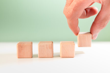 Hand arranging wooden block stacking as step stair, business growth concept.の写真素材