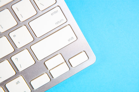 Close up of white computer keyboard on blue background with copy space.の写真素材