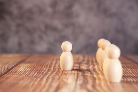 Wooden figures of people on a wooden background. The concept of teamwork and cooperation.