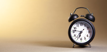 Retro alarm clock on a brown background with copy space for text