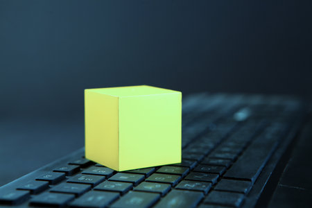Conceptual image of a yellow cube on a computer keyboard.の写真素材