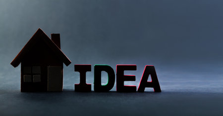 The word idea and the silhouette of a wooden house on a dark background.の写真素材