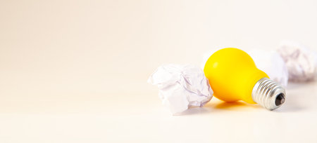 Light bulb and crumpled paper on white background with copy spaceの写真素材