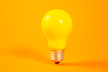 Yellow light bulb on orange background, concept of new ideas and creativity