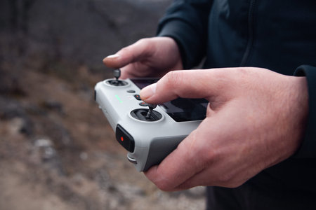 Hands of man holding remote control of drone. Selective focus.