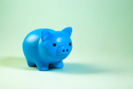 Blue piggy bank isolated on green background with copy space for textの写真素材
