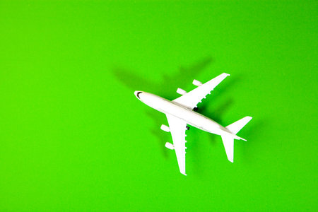 Airplane model isolated on green background. Travel and vacation concept.の写真素材