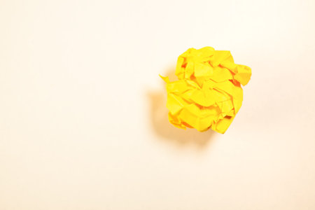 Crumpled yellow paper ball on white background with copy space.の写真素材