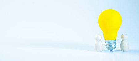 Idea concept with yellow light bulb and people figure on blue backgroundの写真素材