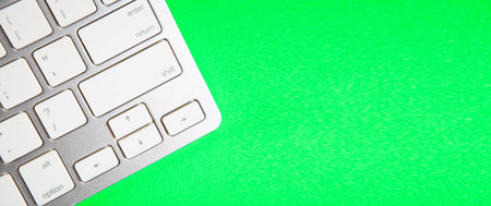 Close up of white computer keyboard on green background with copy space.の写真素材