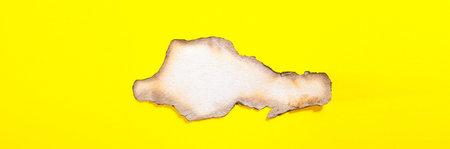 Torn piece of paper on a yellow background. View from above.