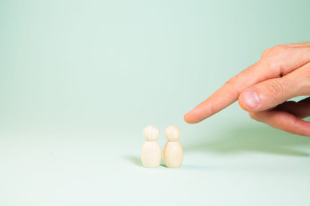 a man holds the two small figures of a person in his hand.の写真素材