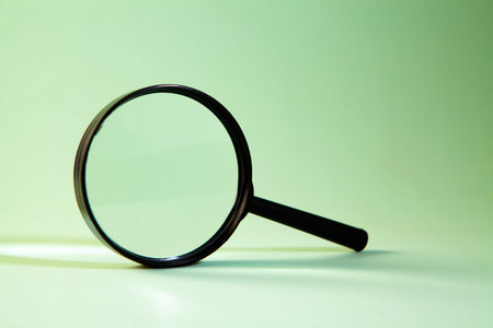 Magnifying glass on a green background.の写真素材