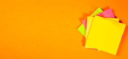 Colorful sticky notes on orange background. Copy space for text.