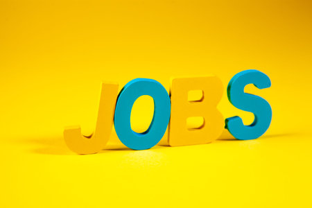 Jobs word made with colorful wooden letters on a yellow background.
