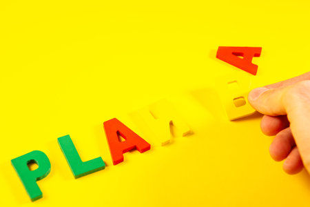 Plasticine letters spelling the word plan on a yellow background.