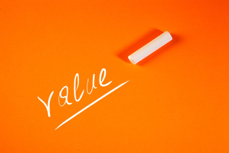 White chalk on an orange background with the word written in it