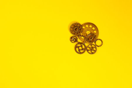 Metal gear wheels on yellow background. Flat lay, top view.