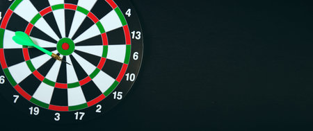 Dartboard with dart arrow on black background, Business target concept.