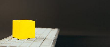 Yellow cube on computer keyboard with copy space, business and technology concept
